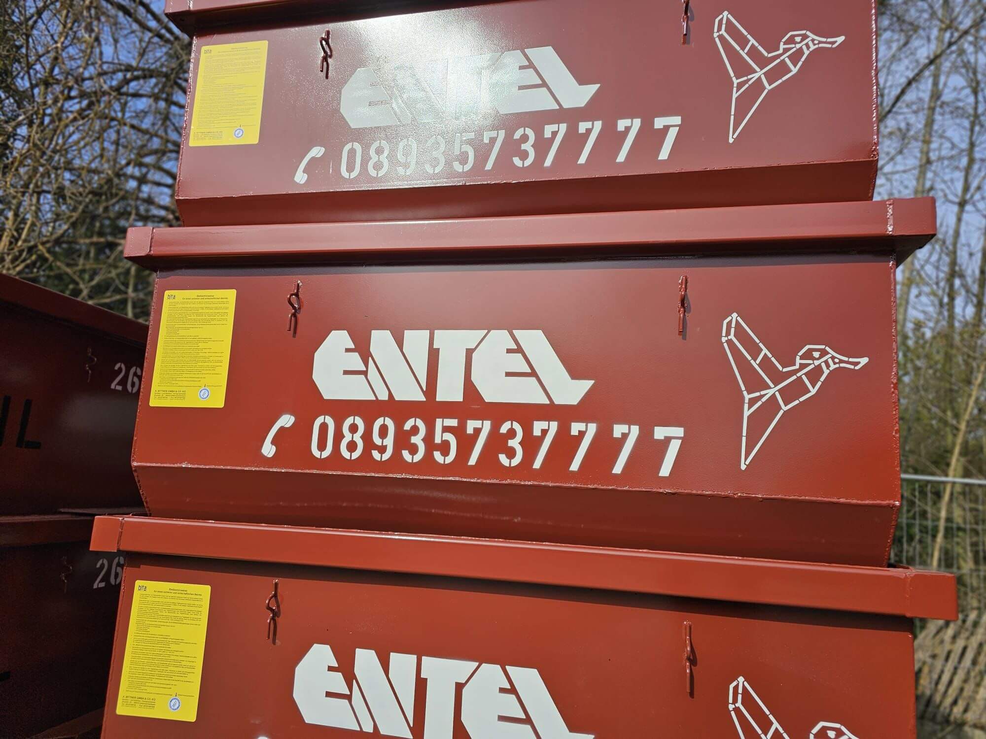 Nahaufnahme der ENTEL-Beschriftung mit Firmenlogo und Telefonnummer auf einem Absetzcontainer