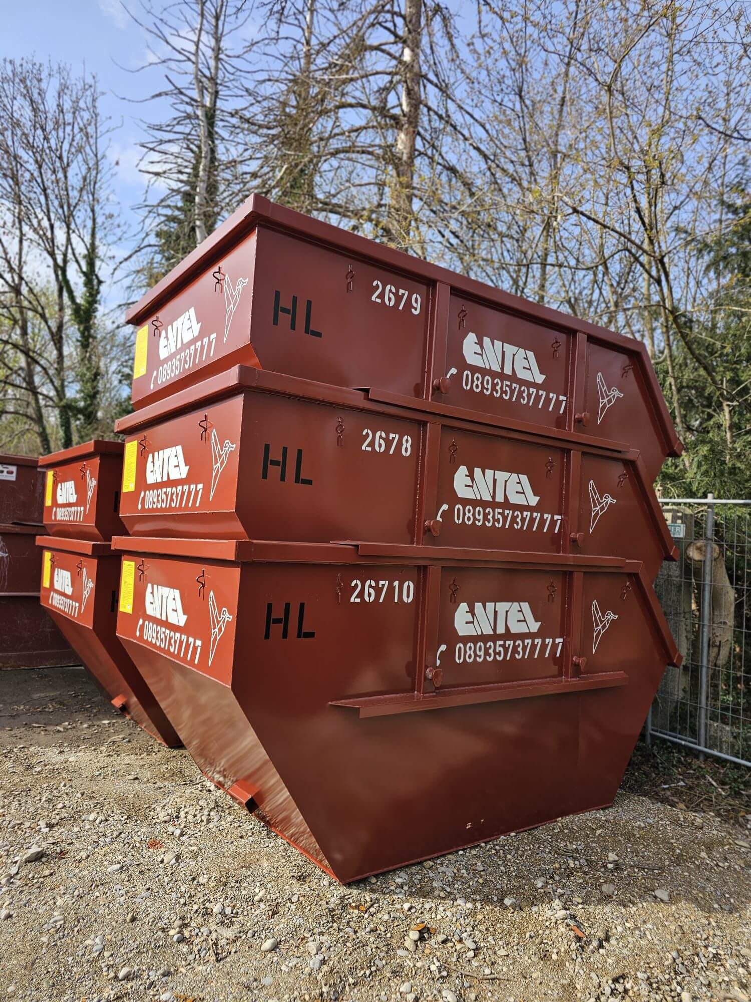 Drei gestapelte Entel-Absetzcontainer mit Firmenlogo und Kennnummern, seitliche Ansicht